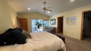 A bedroom with a large bed, a ceiling fan, a door leading to a balcony, and a framed picture on the wall. - Relaxing, Spacious 5-bedroom Tahoe Home Monthly Rental (Incline Village)