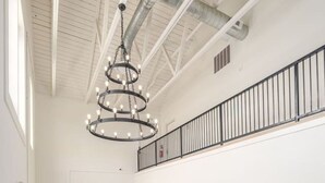 A spacious interior with a modern staircase, a chandelier, and artwork on the walls. - Fabulous Flat in Trussville! (Trussville)