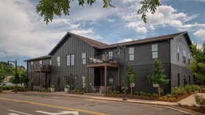 A modern two-story building with a flat roof, large windows, and a covered entrance with steps. - Fabulous Flat in Trussville! (Trussville)