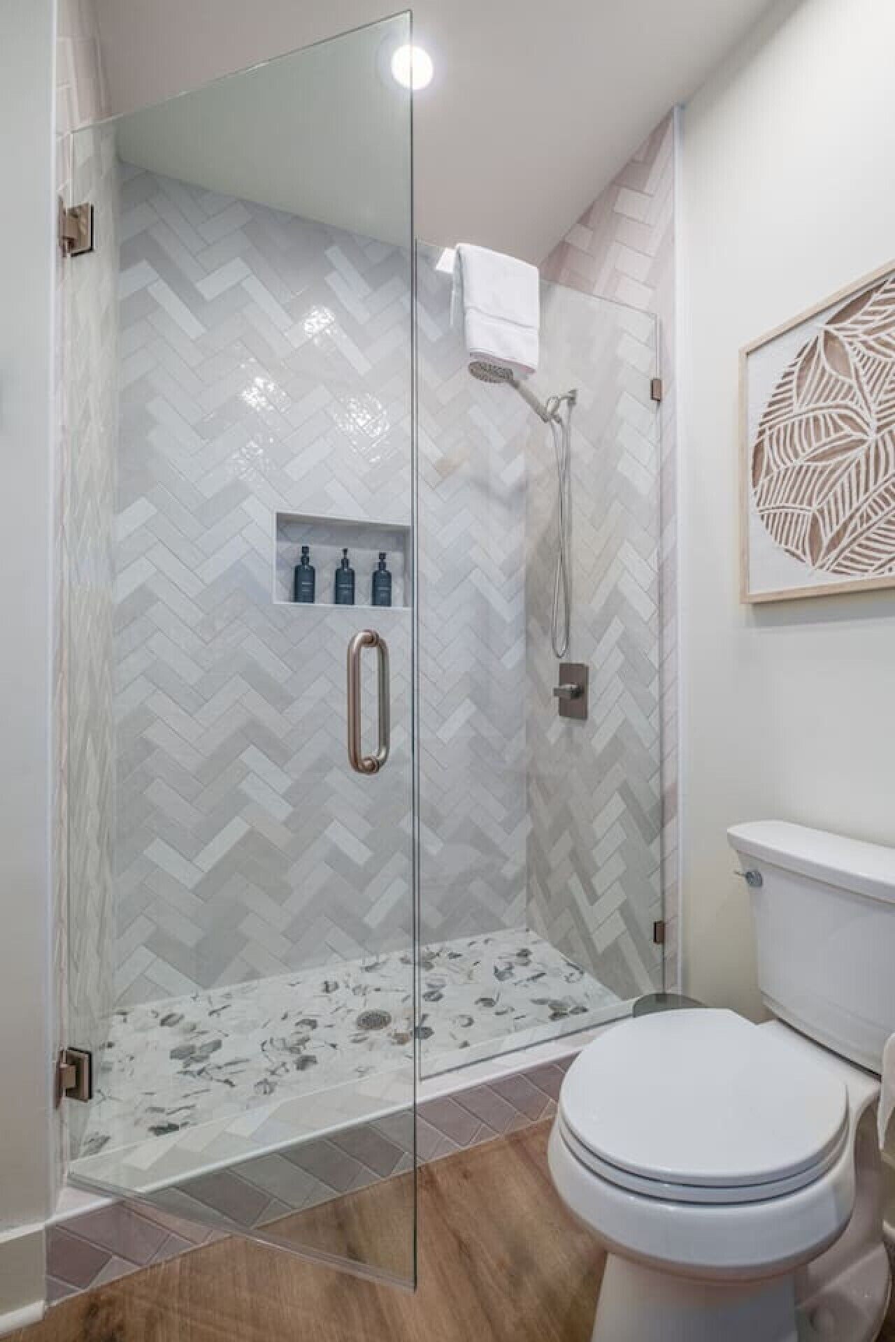 Une salle de bain avec une douche à parois de verre, des toilettes et un lavabo.