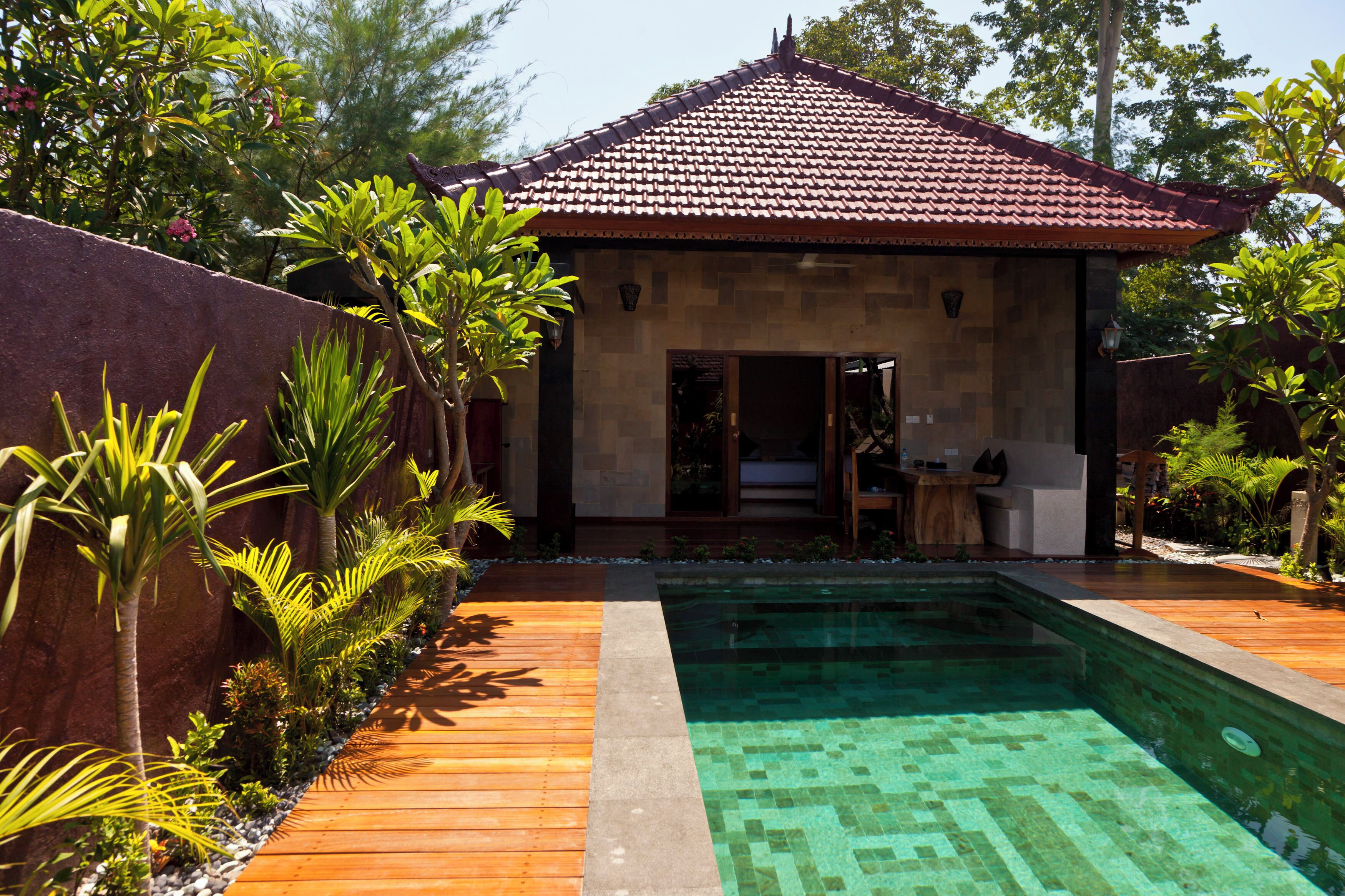 A house with a tiled roof, a swimming pool, and a wooden deck.