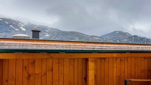 Eine Holterrasse mit Blick auf schneebedeckte Berge.