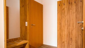 Une pièce comprenant une armoire en bois, un miroir et un bureau en bois.
