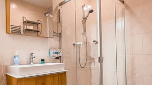Une salle de bain moderne avec une douche à parois de verre, un meuble-lavabo en bois et des toilettes.