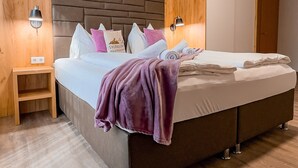 Une chambre à coucher moderne avec un grand lit, une tête de lit en bois, des tables de chevet et une table de nuit.