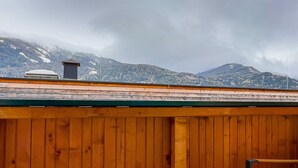 Eine Holterrasse mit Blick auf schneebedeckte Berge.