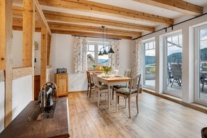 A dining area with a wooden table, chairs, and a sewing machine. - Apartment 'Ferienwohnung Rinkenberg' with Private Terrace and Wi-Fi (Baiersbronn)