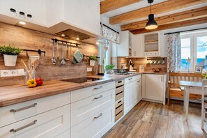 A modern kitchen with wooden countertops, white cabinetry, and a wooden ceiling. - Apartment 'Ferienwohnung Rinkenberg' with Private Terrace and Wi-Fi (Baiersbronn)