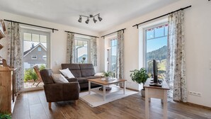 A living room with a sofa, coffee table, and a television on a stand.