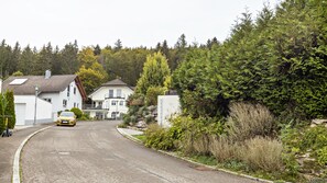 Une maison à deux étages avec un garage, une allée et une voiture jaune garée devant.