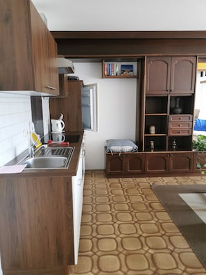 A kitchen with wooden cabinets, a built-in microwave, and a patterned floor.