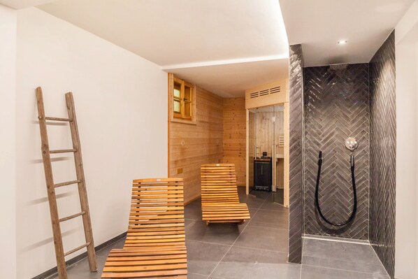 A hallway with wooden benches, a wooden ladder, and a shower area with a herringbone tile pattern.