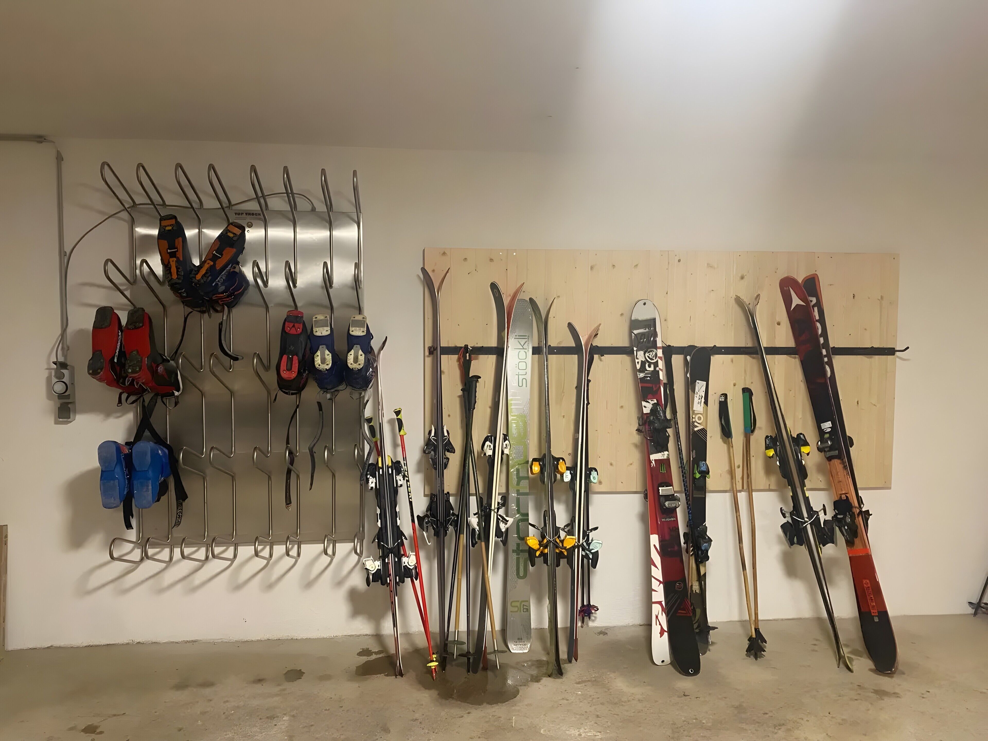 Zona de almacenamiento para esquíes, con varios racks para esquíes y botas de esquí.
