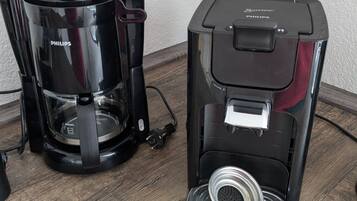 Two coffee makers on a wooden surface.