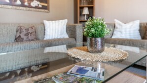 A living room with a glass coffee table, a potted plant, and a magazine. - Apartment 'Ferienwohnung Obenauf' with Private Terrace and Wi-Fi (Oesterwurth)