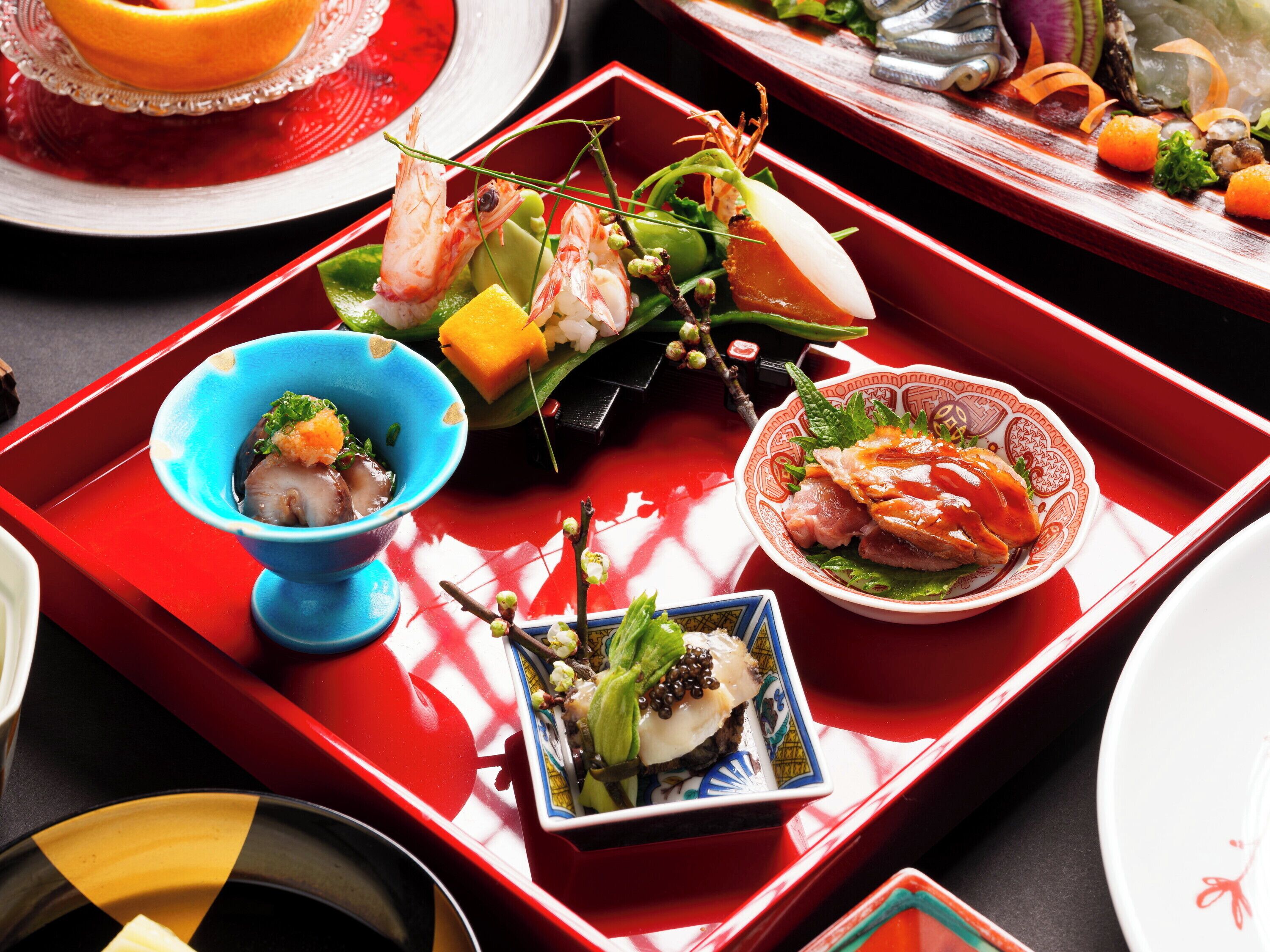 A variety of dishes on a red tray, including seafood and vegetables.