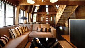 Un intérieur en bois avec un canapé, des lampes et un escalier.