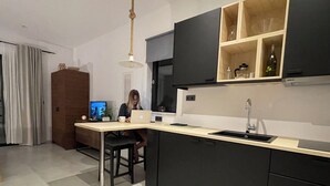 Eine moderne Küche mit einer zentralen Kochinsel, schwarzen Schränken und einer Holz Arbeitsplatte.