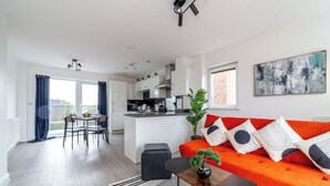 Um apartamento moderno com área de jantar, cozinha e sala de estar.