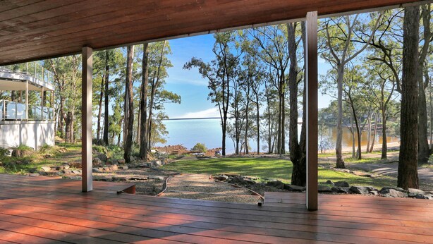 Un espacio al aire libre cubierto con vista a un lago y árboles.