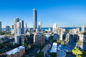 A cityscape with high-rise buildings, a prominent skyscraper, and a view of the ocean.