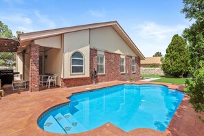 Una casa con piscina, patio y zona de estar al aire libre.
