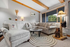 Una sala de estar con sofá, sillón, mesa de centro y lámpara.