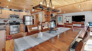 Une cuisine spacieuse avec des meubles en bois, un îlot central et un luminaire suspendu.