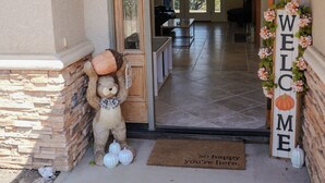 A house entrance with a welcome sign, a teddy bear, and a doormat. - Thoughtfully Designed for Accessibility and Family-Friendliness. (Mariposa)