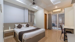 A modern hotel room with a bed, desk, chair, and a view of the outside. - Grace Apart Hotel (Kanayannur)