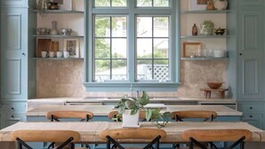 A kitchen with a large window, wooden chairs, and shelves with various items. - High Street Inn W High St Room (Charlottesville)