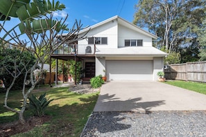 A single-story house with a garage, a covered porch, and a well-maintained lawn.