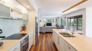 A modern kitchen with a central island, built-in appliances, and large windows.