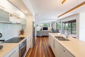 A modern kitchen with a central island, built-in appliances, and large windows.