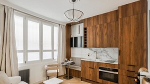Eine moderne Küche mit Holzausstattung, einer Marmorarbeitsplatte und einem eingebauten Ofen.