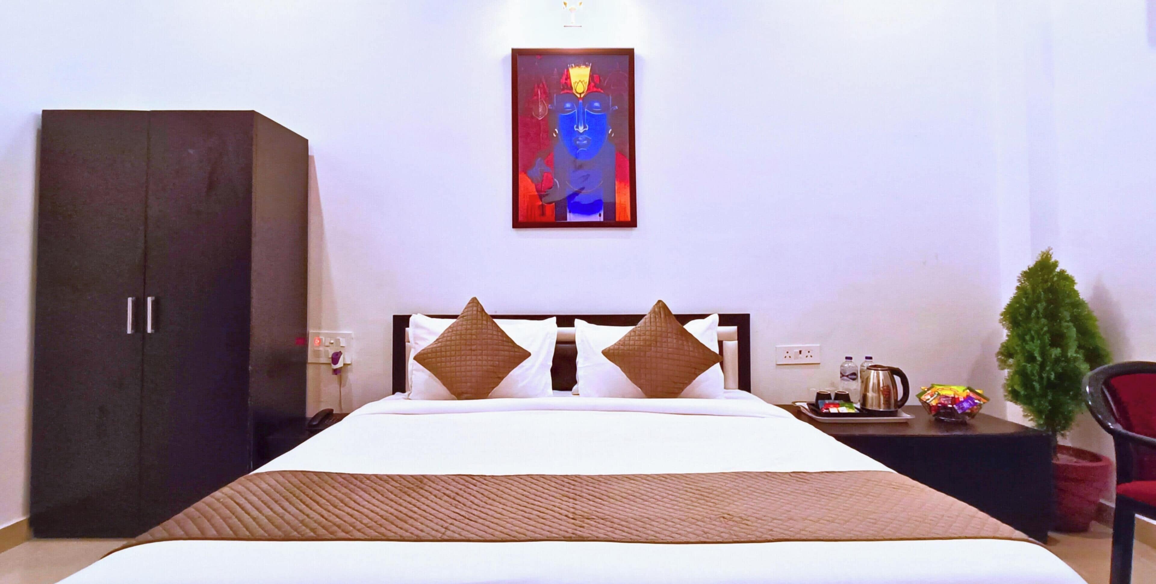 Een hotelkamer met een bed, een kledingkast, een nachtkastje, een koffiezetapparaat en een kleine plant.