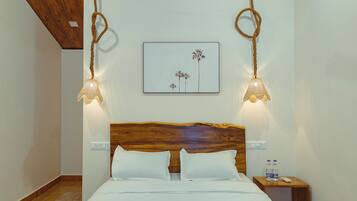 Cozy retreat with a neatly made bed, wall-mounted lamps, and a framed artwork above.