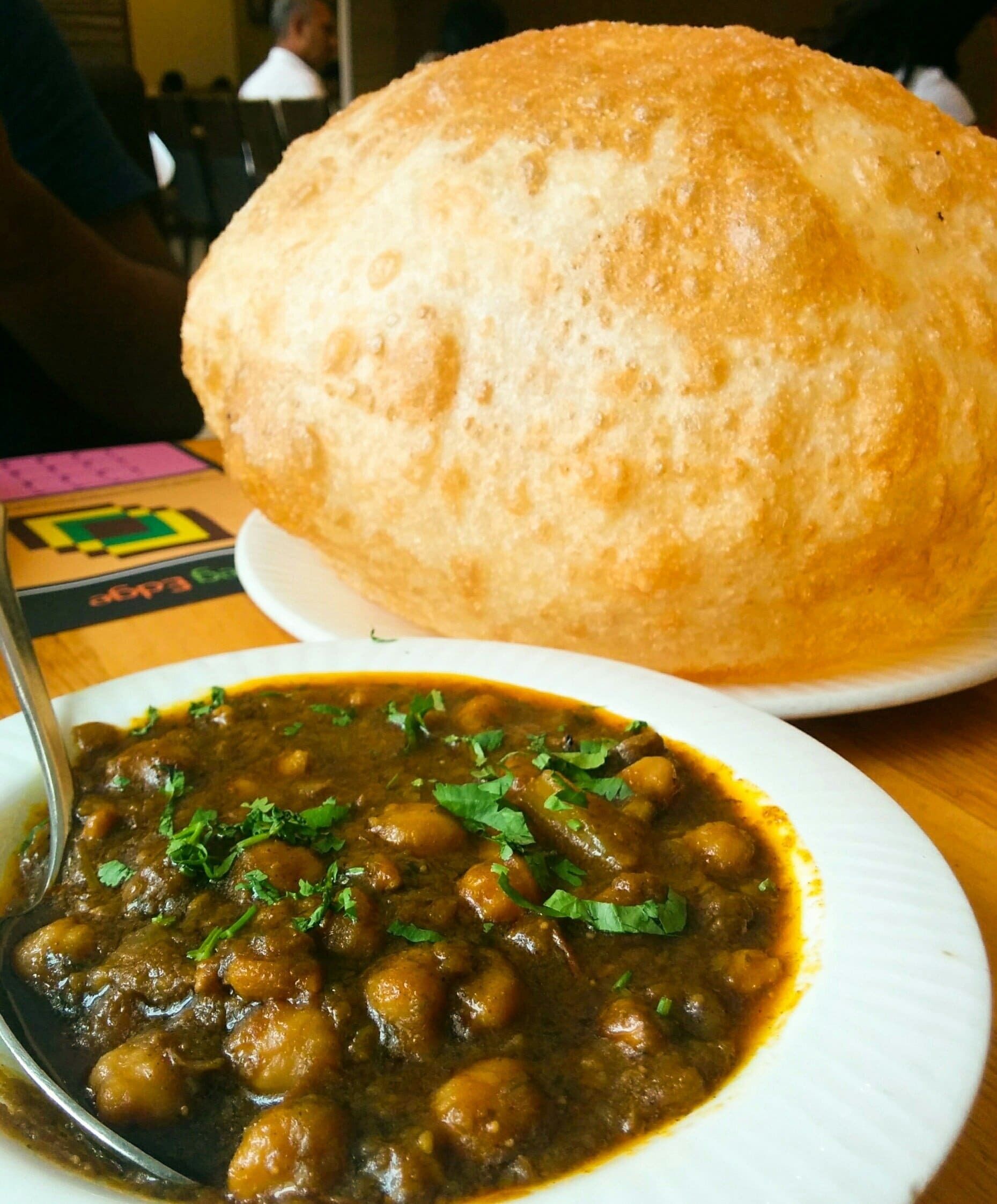 A plate of food with a bread roll beside it.