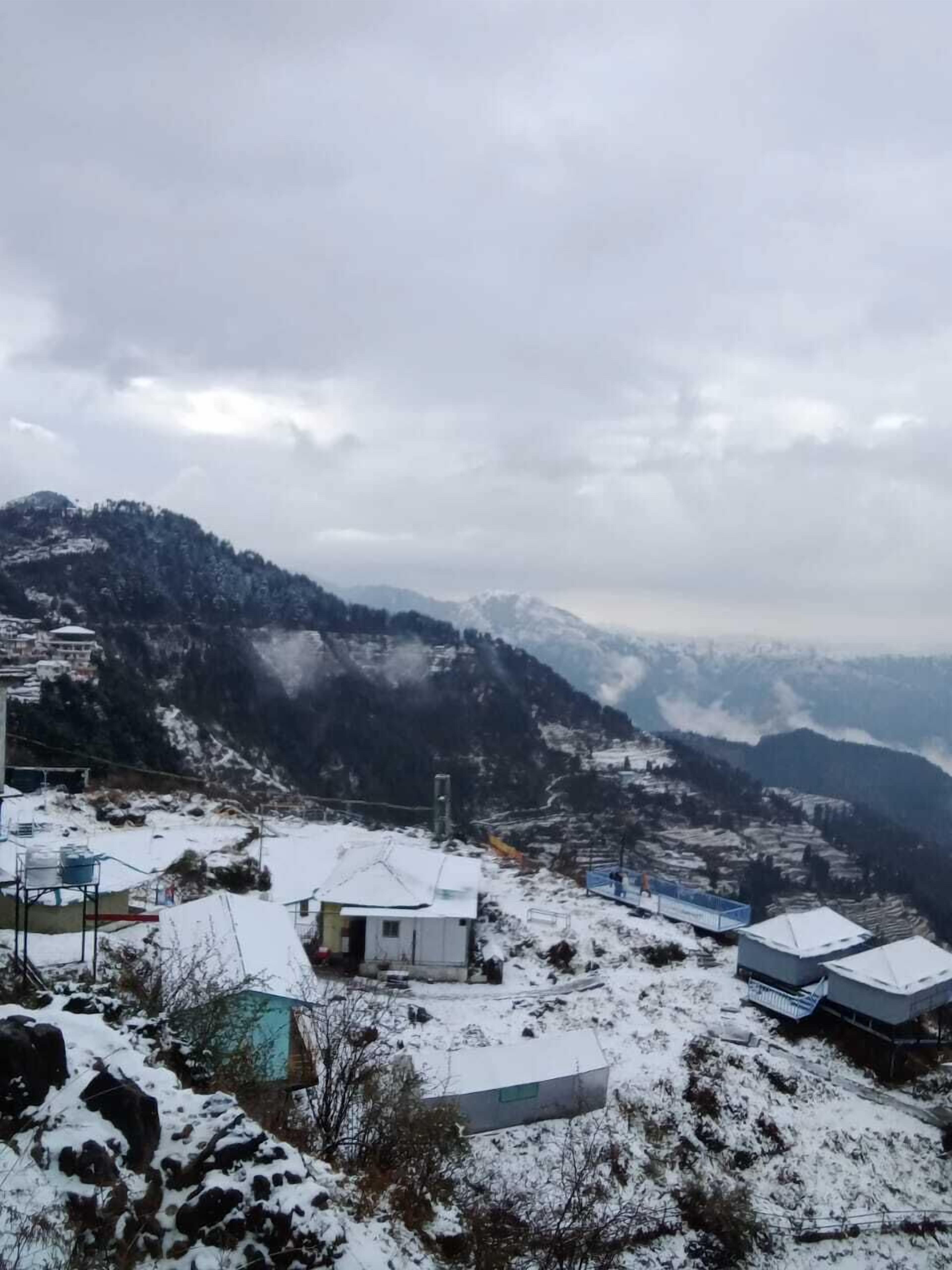 A mountainous landscape with snow-covered buildings and a clear sky.