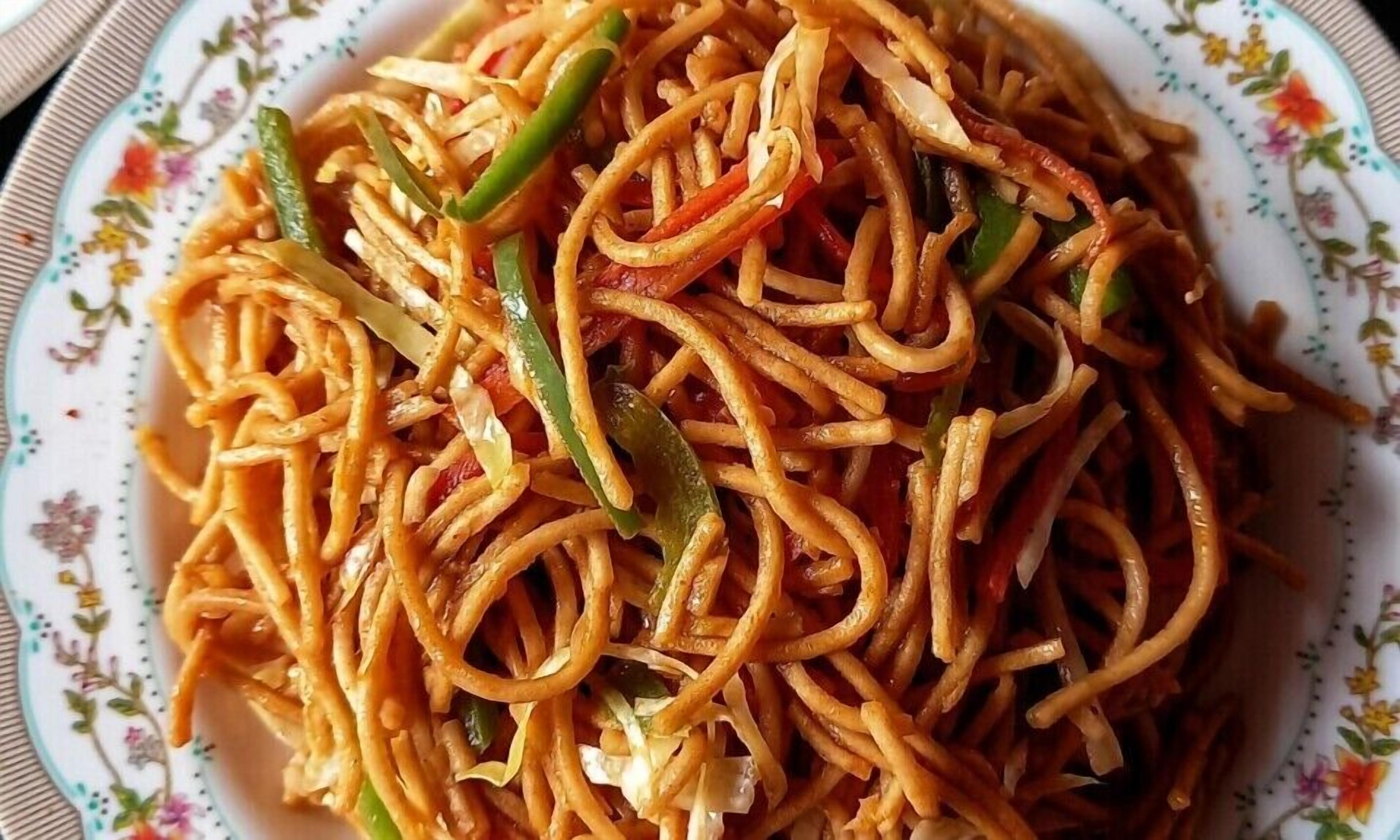 A plate of stir-fried noodles with vegetables.