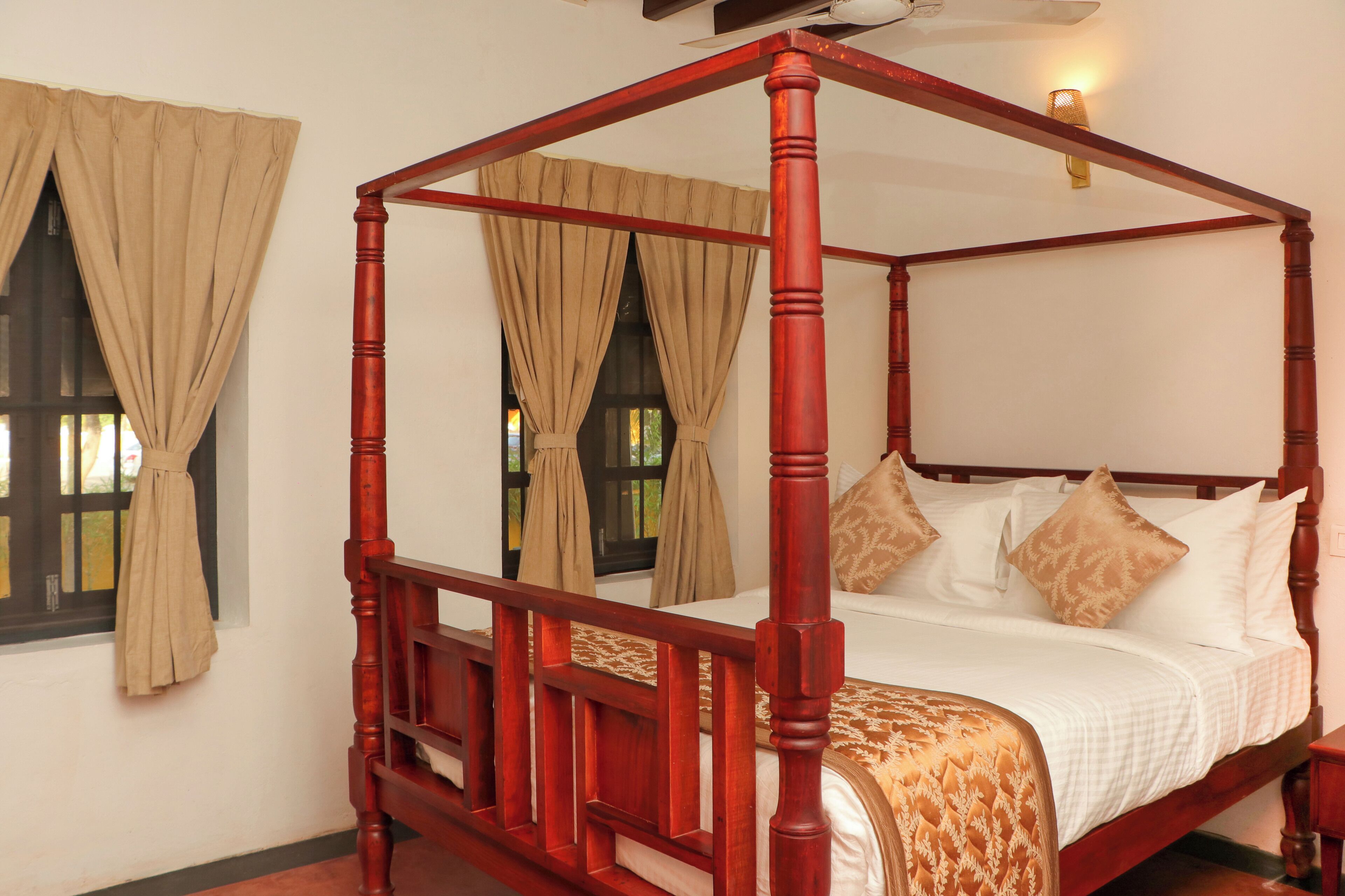 A four-poster bed with a wooden frame and a white bedspread.
