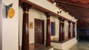 A corridor with wooden columns, a door, and a staircase. - FRANCO TAMIL VILLAS (Puducherry)