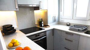 A modern kitchen with white cabinets, a built-in oven, a sink, and a window. - Beautiful and comfortable villa in Calpe, Costa Blanca, Spain  with private pool for 4 persons (Calpe)