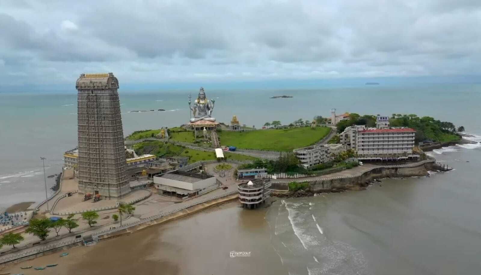 Vue aérienne d’une zone côtière avec une tour imposante, un temple et un hôtel.