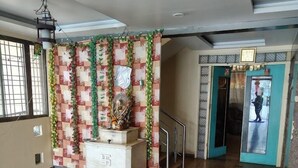 Un vestíbulo amplio con una recepción, una escalera y una puerta que da a otra zona.