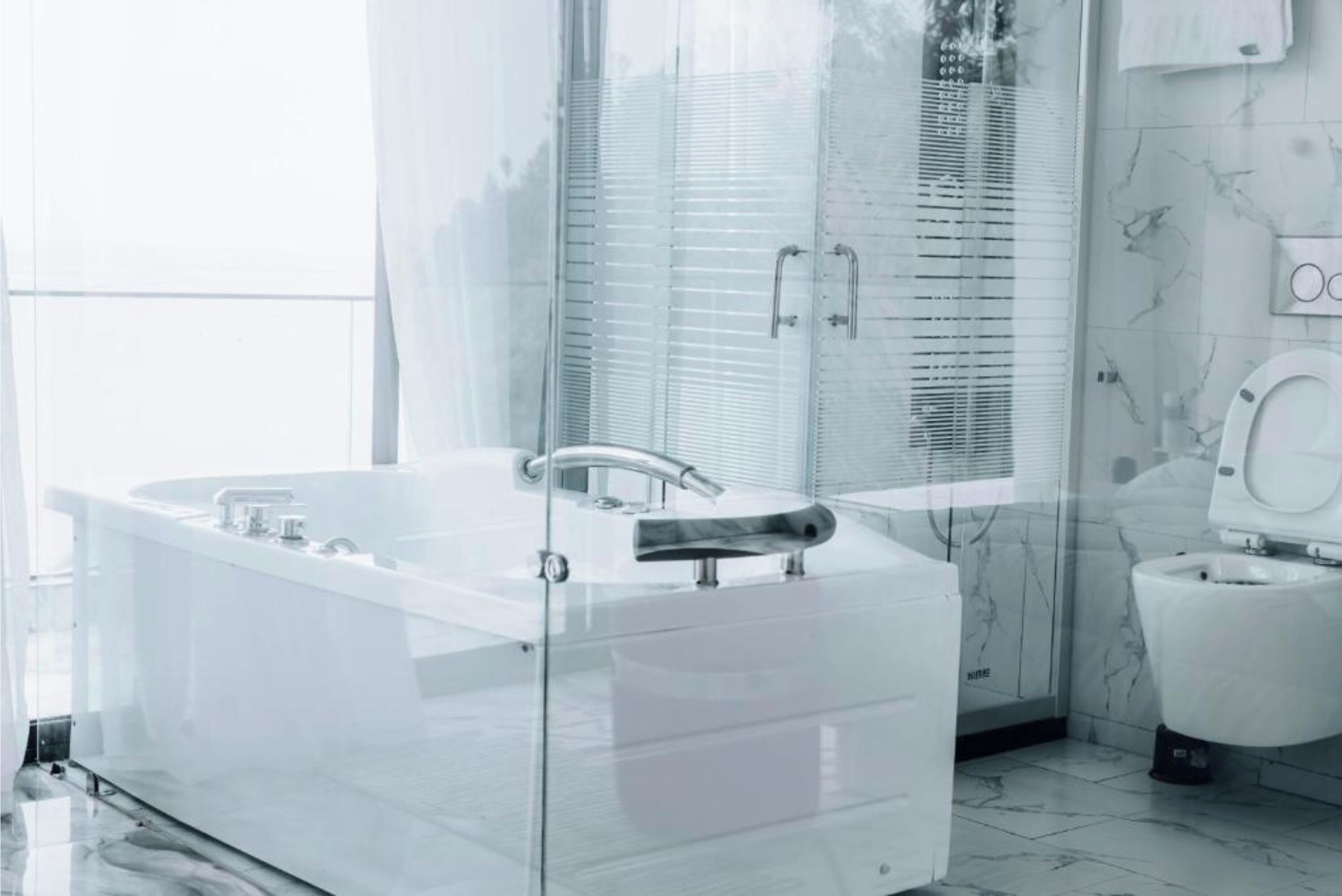 Un bagno moderno con cabina doccia in vetro, una vasca da bagno bianca e un water.