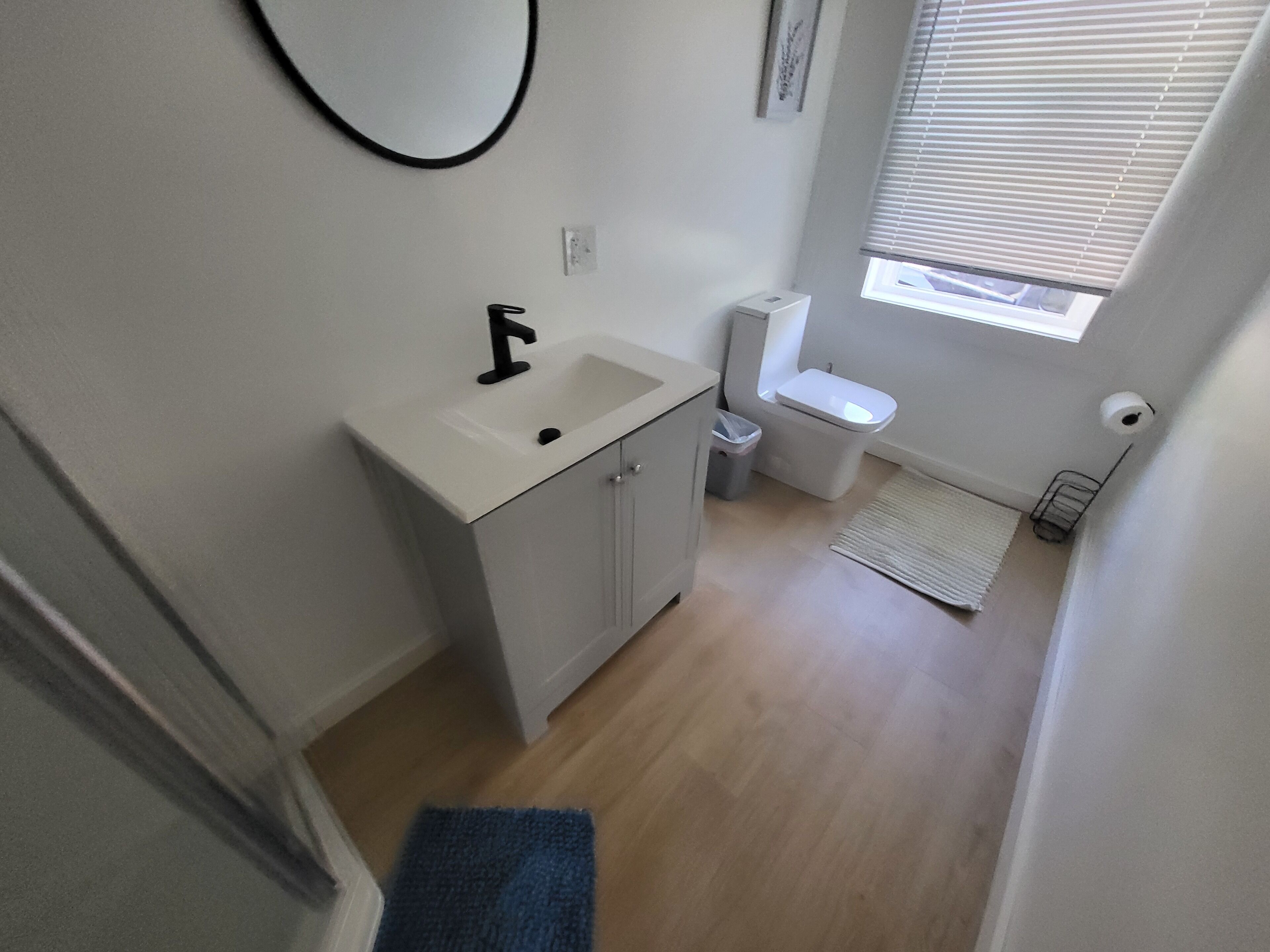 Un baño pequeño con lavamanos, inodoro y un ventanal.