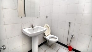Un baño pequeño con lavamanos, inodoro y ducha.
