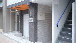 A modern building entrance with a sign reading "Metro Gate MORISHITA," a staircase with blue handrails, and a tiled exterior. - Metro Gate Morishita (Tokyo)