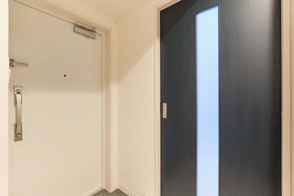 A room with a white door and a dark wooden door. - Metro Gate Morishita (Tokyo)